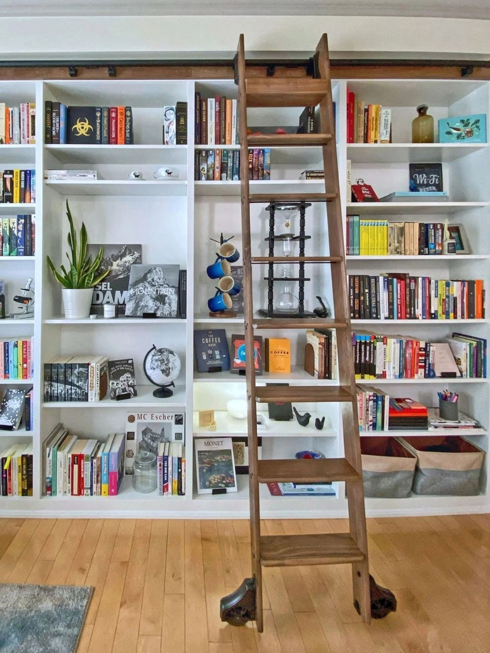 Rolling library ladder on white built in bookshelves.