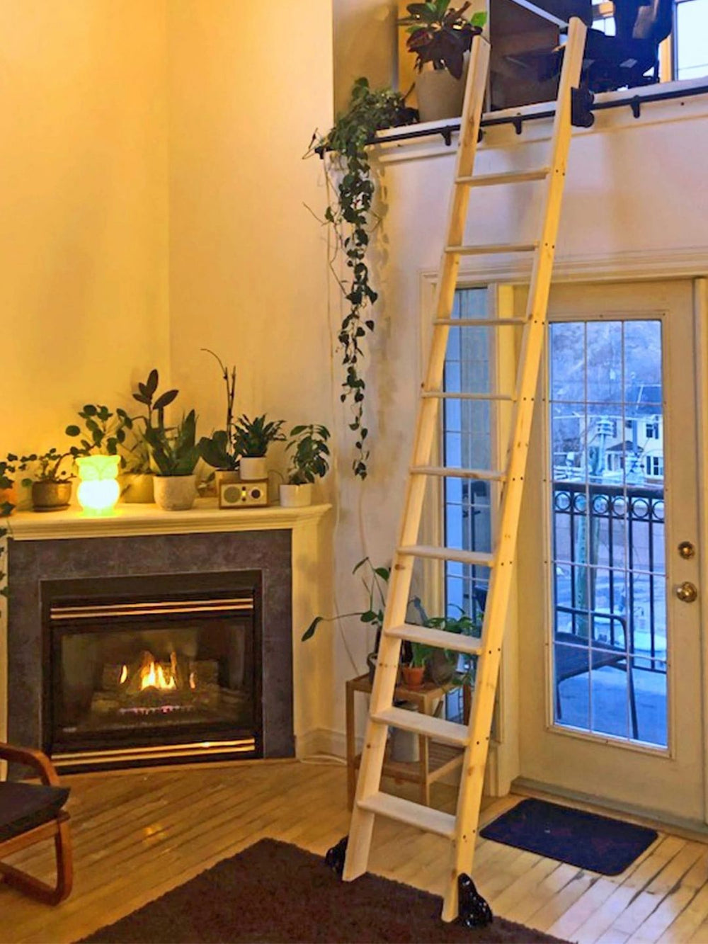 Loft ladder beside a corner fireplace.