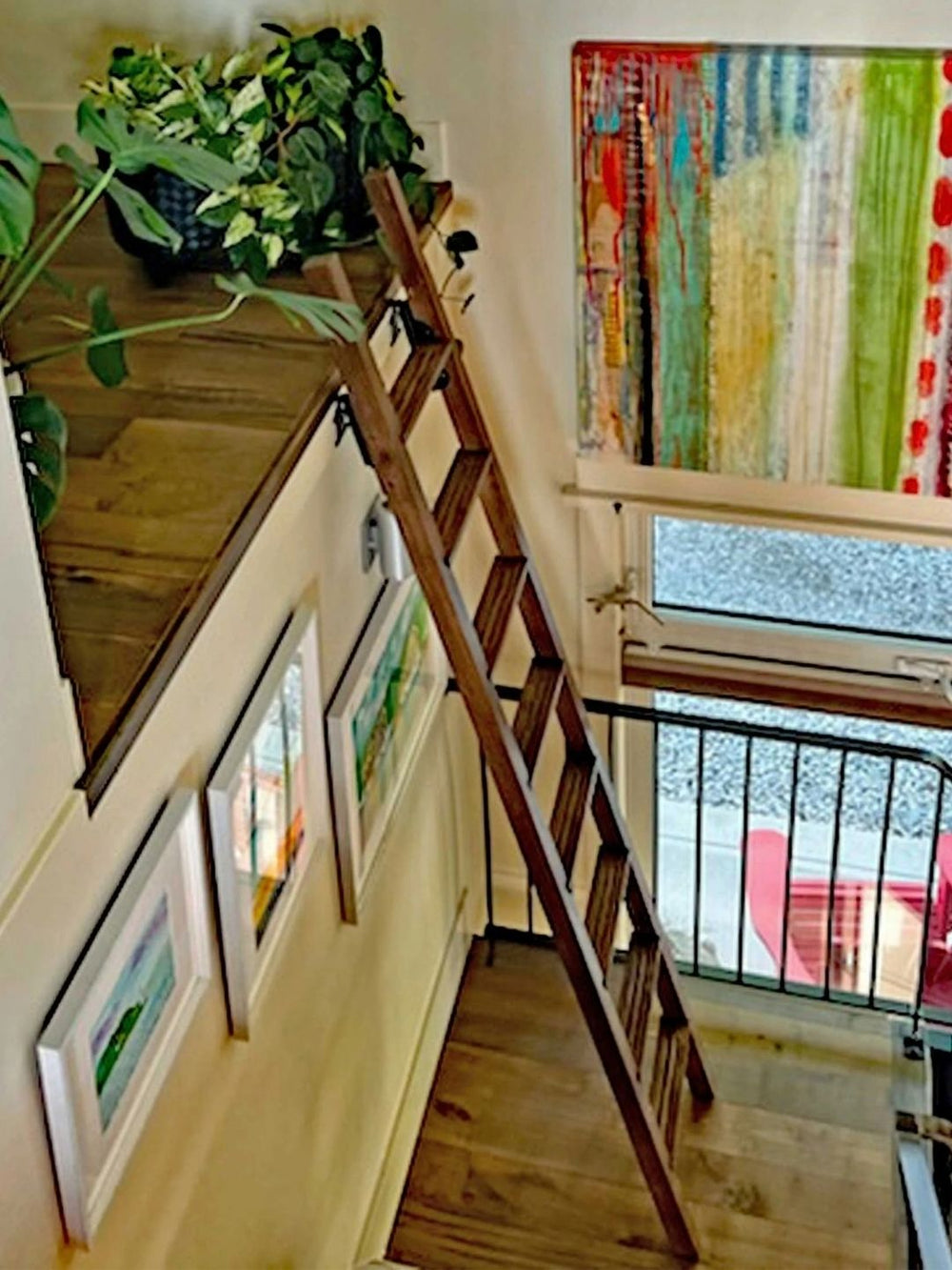 Amsterdam ladder leading to a loft above a stairwell landing.