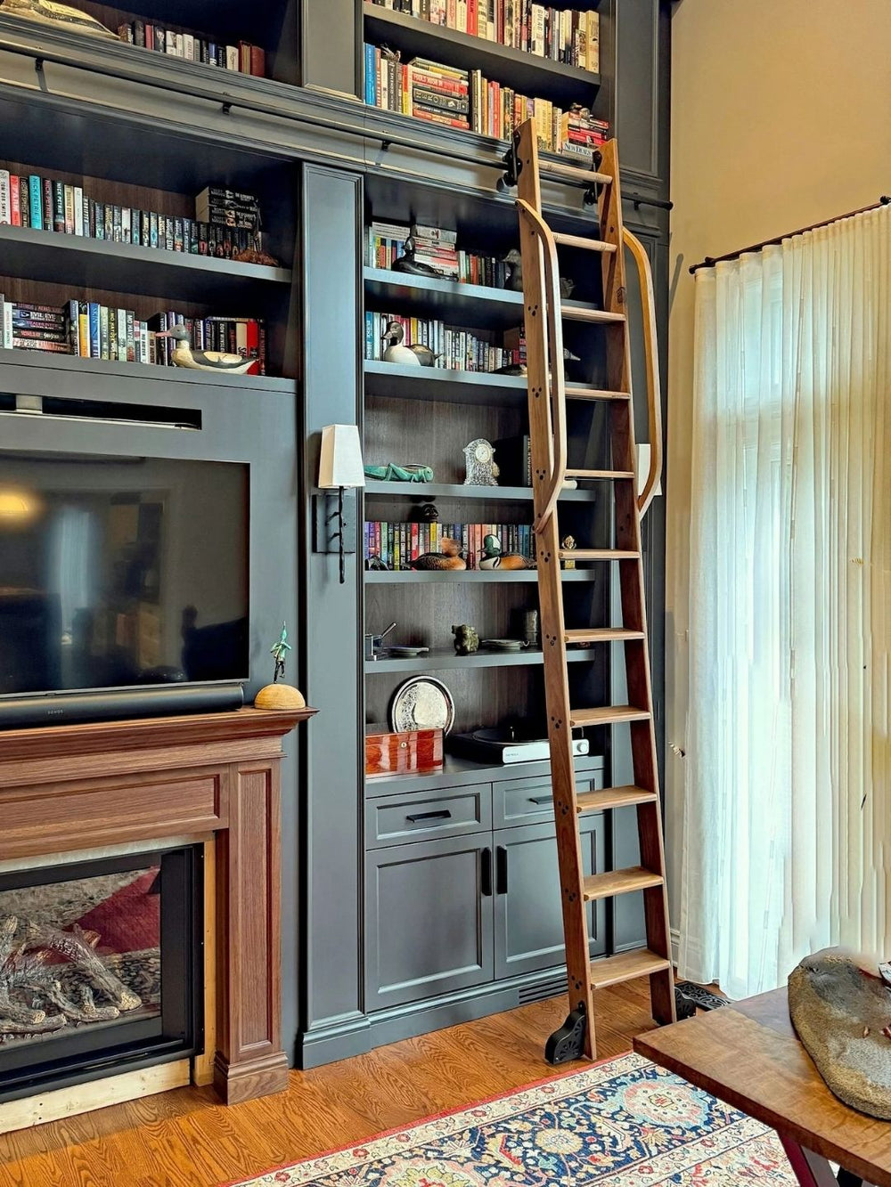 Classic ladder on dark built in bookshelves.