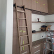 Library ladder kit in walnut, installed on shelving.