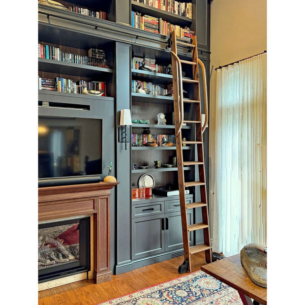 Library ladder kit on dark built in bookshelves beside a fireplace.
